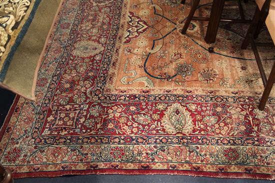 A Kerman carpet, the rose madder field with an all over medallion design, 15ft 10in. x 11ft 8in. (worn)